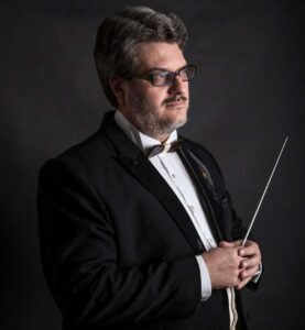 Portrait photograph of conductor Konstantin Ilievsky holding the conductor's baton. 